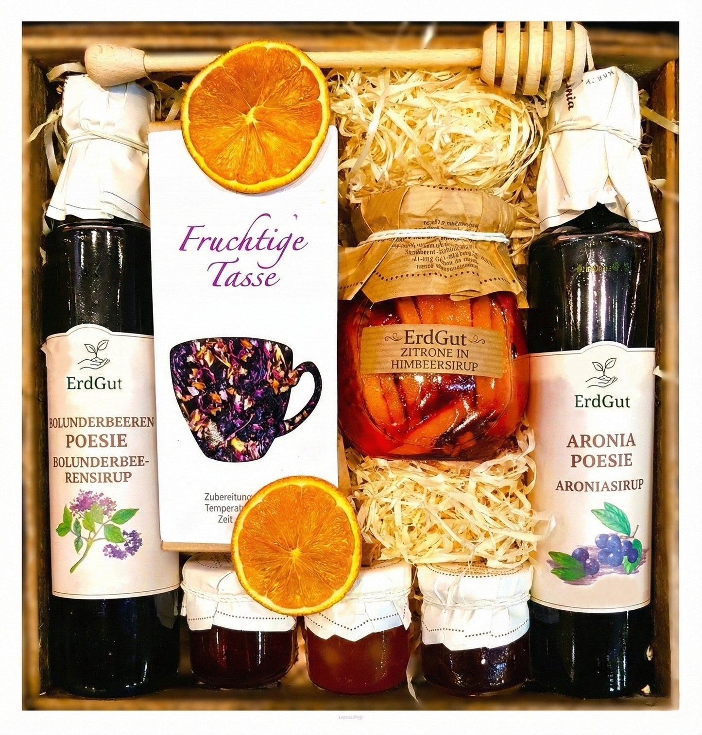 Geschenkkorb mit Honig, Tee, Zitronen und Himbeersirup.
