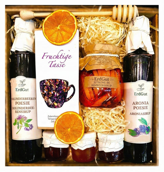 Geschenkkorb mit Honig, Tee, Zitronen und Himbeersirup.